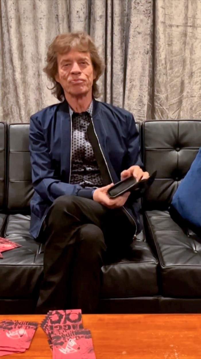 Mick Jagger stă pe o canapea