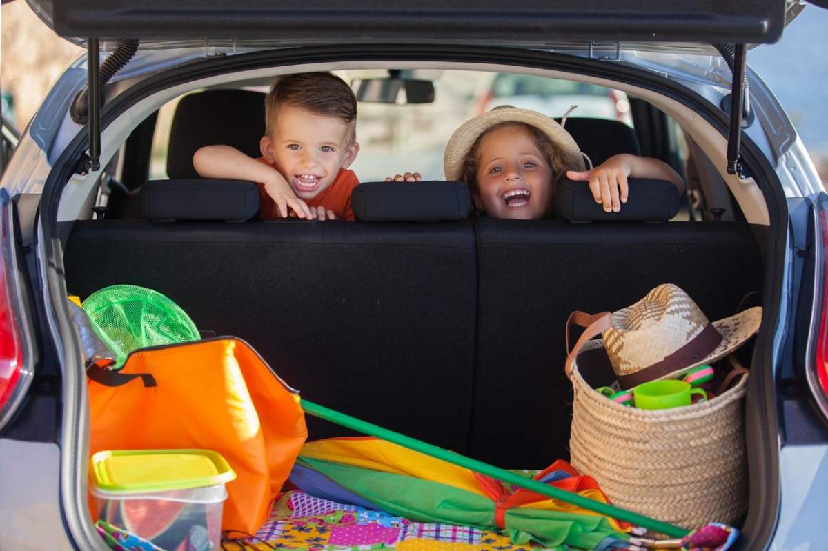 Copii entuziasmați în mașină care sosesc în vacanța de vară