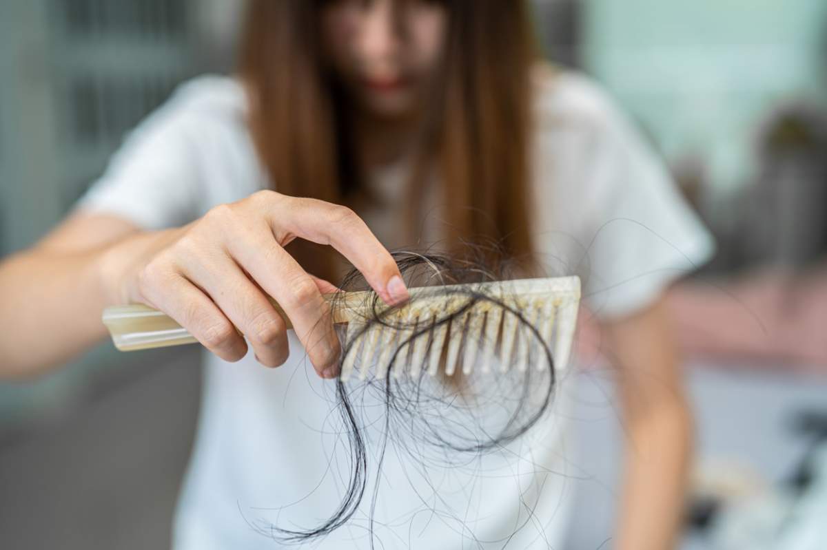 Femei care are probleme cu căderea părului lung, atașat pe un pieptene
