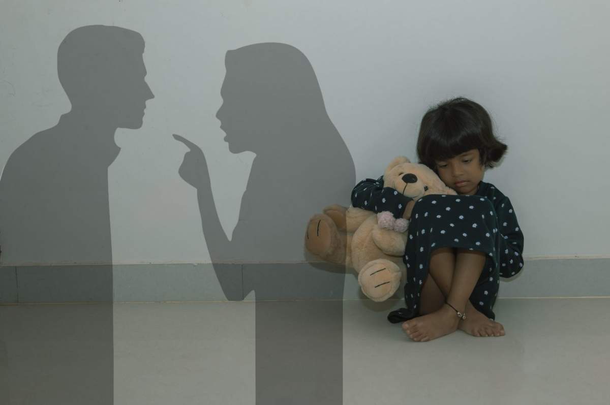O fetiță tristă și singură urmărește îngrozită cum părinții ei se luptă în siluetă