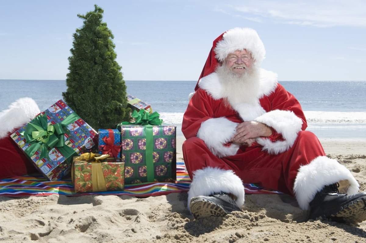 Moș Crăciun cu cadouri pe plajă