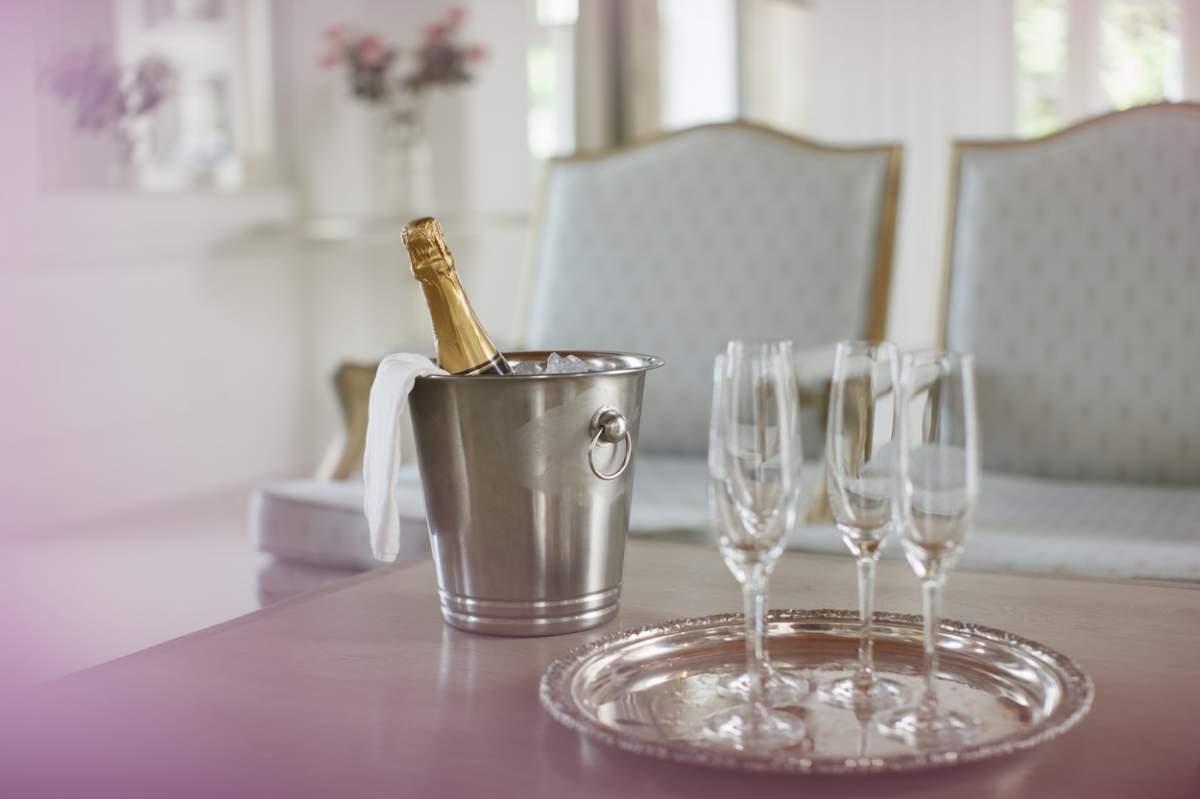 O sticlă de șampanie și pahare pe o masă