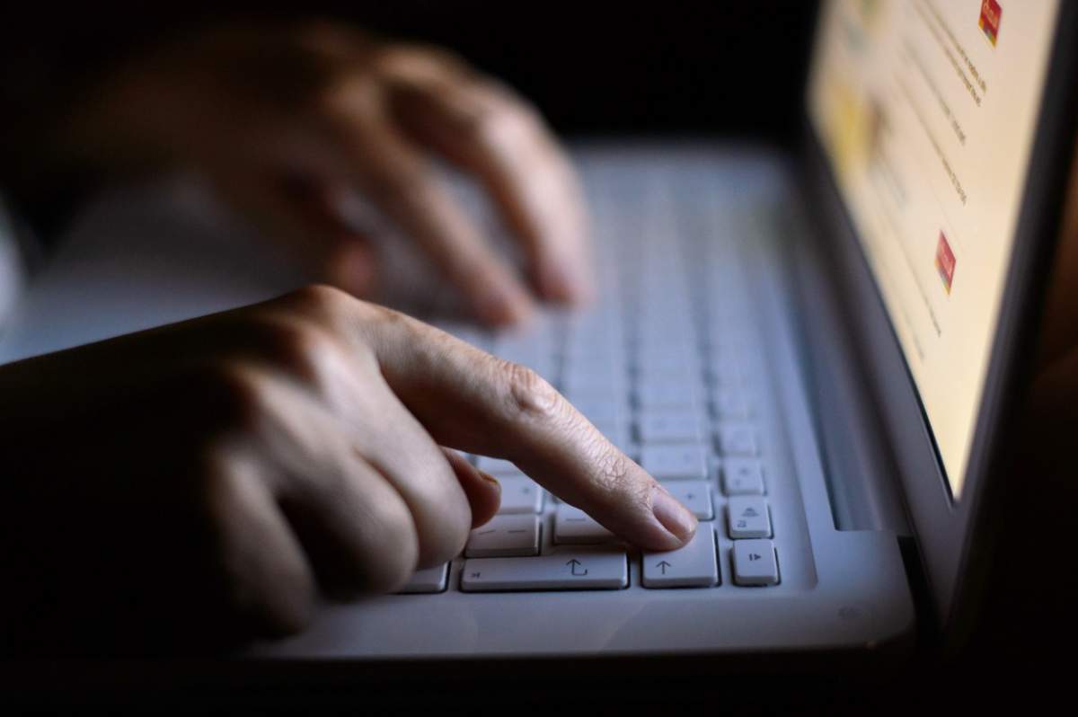 O persoană care scrie la laptop