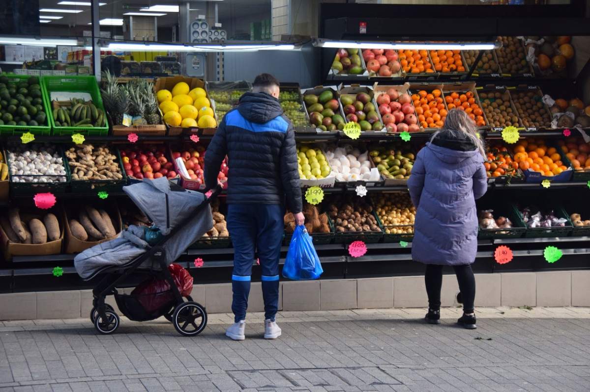 Doi oameni care se uită la fructe și legume.