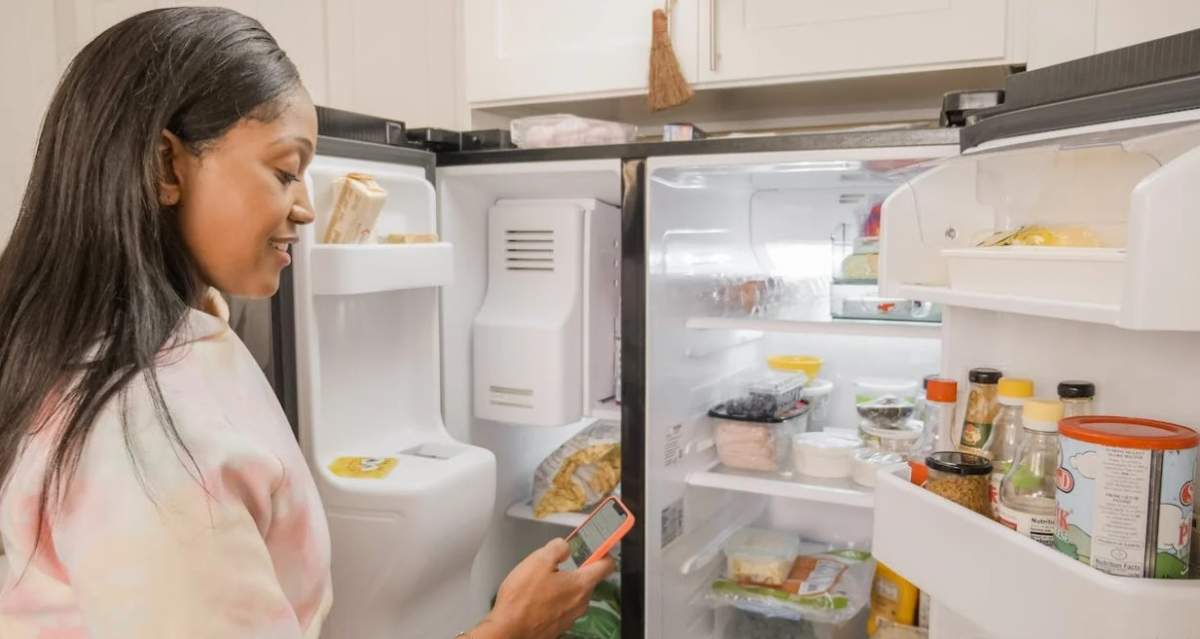 femeie care se uită în frigider