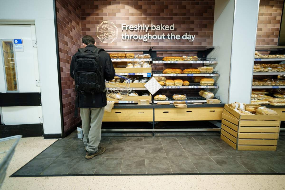 o persoană și rafturi cu pâine în magazin