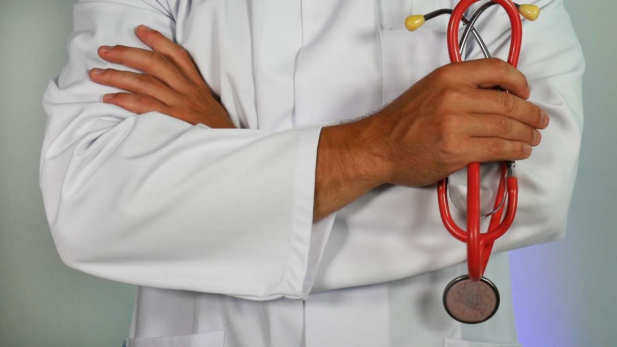 un medic cu un stetoscop în mână și în halat alb