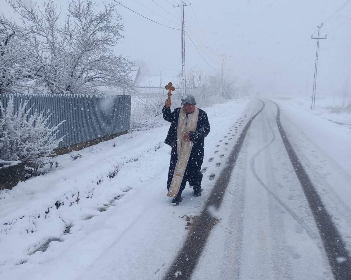 Un preot a ieșit să facă molifta în ninsoare. preot pe stradă în Filipești
