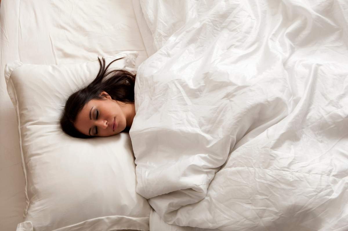 O femeie doarme într-un pat