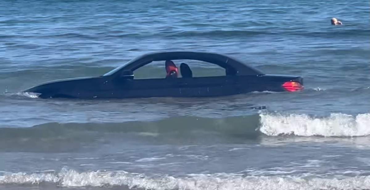 mașina șoferului plutin în mare.