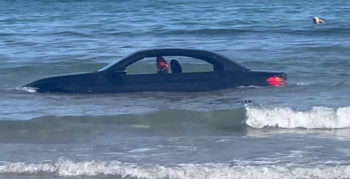 mașina șoferului plutin în mare.