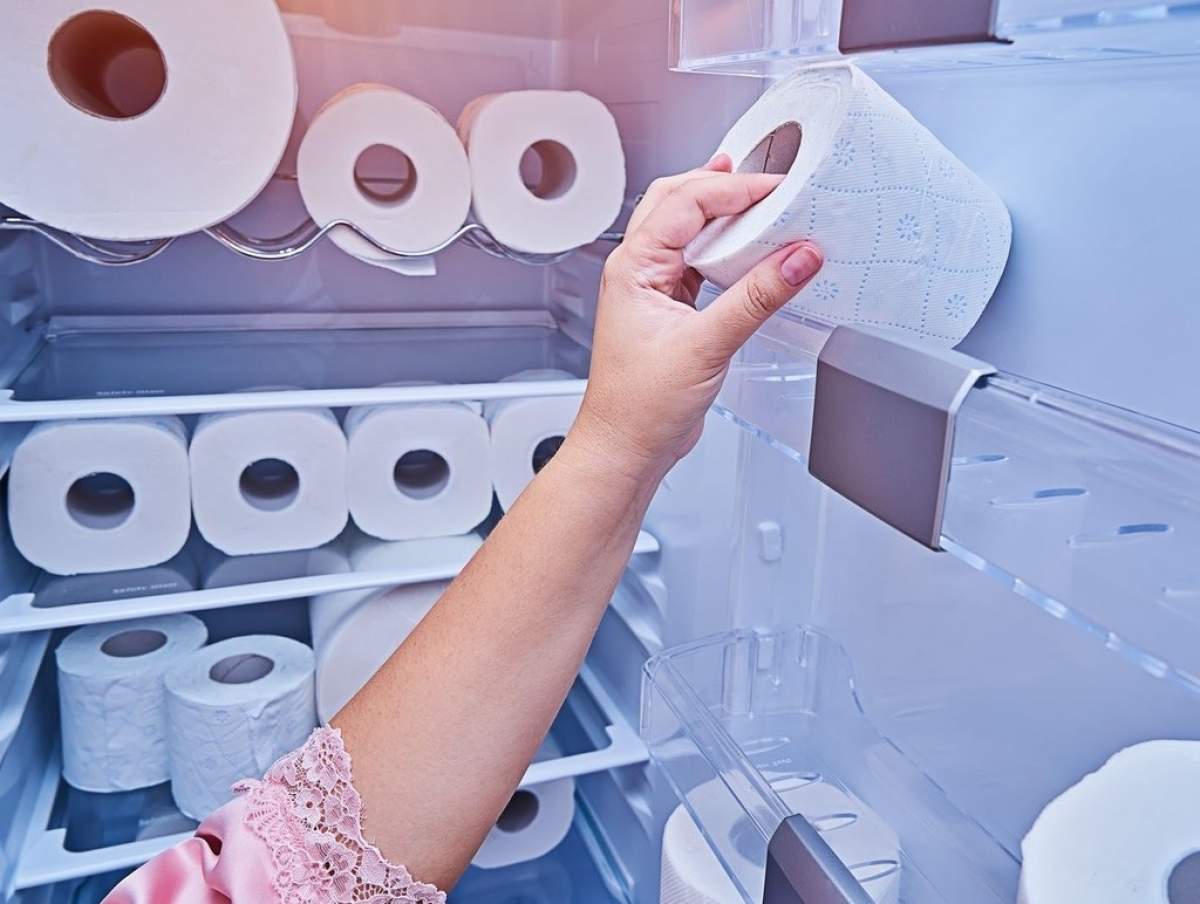 mâna femeii ia rola de hârtie igienică din ușa frigiderului