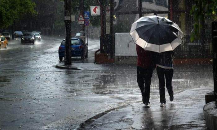 oameni cu umbrelă pe stradă