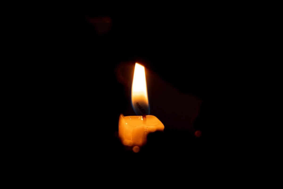 lumina unei lumânări aprinse noaptea, doliu și religie