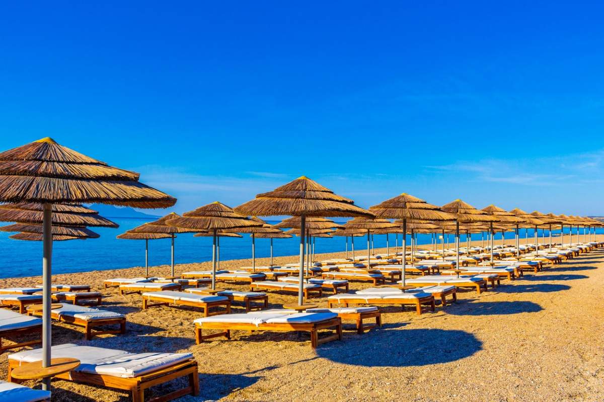 Șezlonguri și umbrele pe o plajă din Grecia