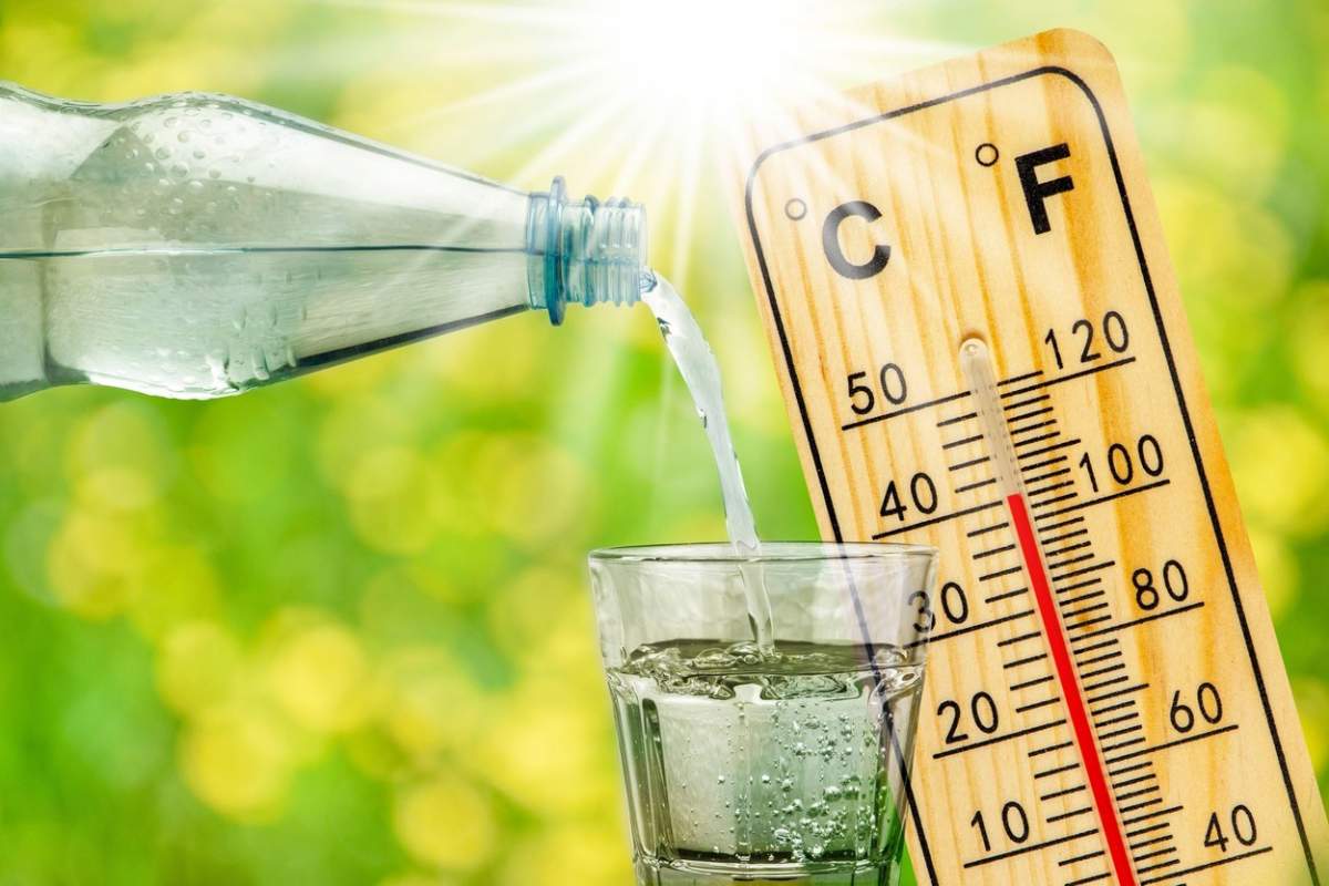 termometrul care arată temperatura ridicată în căldura verii și sticla cu apă cu pahar de băut