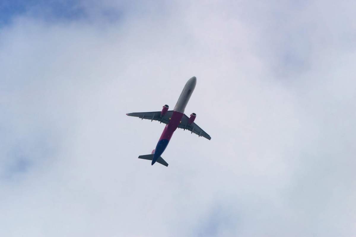 Cluj-Napoca, România - 17 septembrie 2022: Un avion Wizz Air este văzut zburând pe cer în Cluj-Napoca. Această imagine este doar pentru uz editorial.