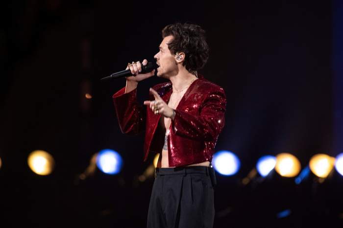 Harry Styles îmbrăcat în roșu cântă la concert