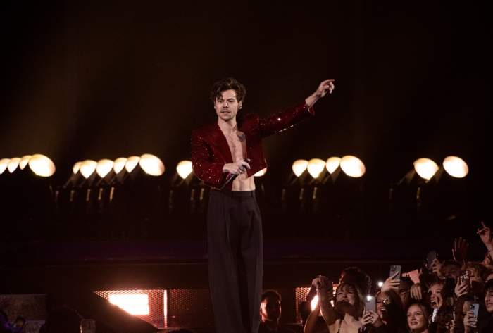 Harry Styles îmbrăcat în roșu cântă la concert
