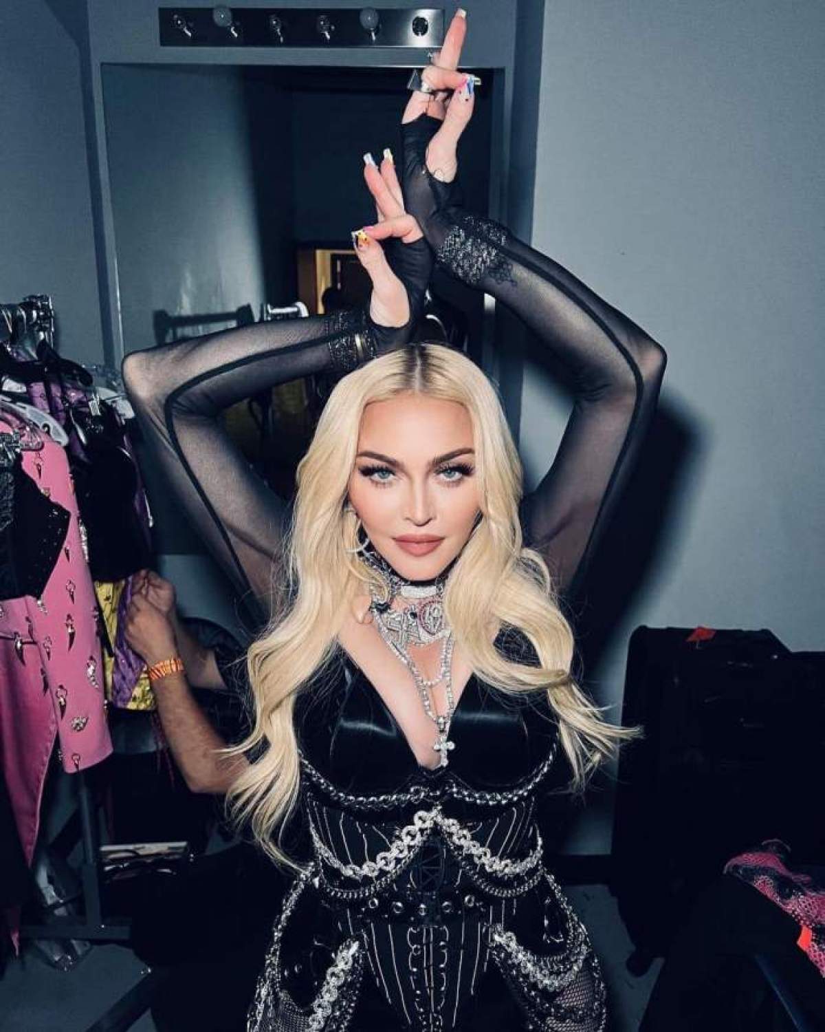 Madonna îmbrăcată în negru stă cu mâinile în sus