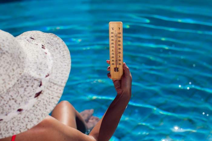 o persoană la piscină cu un termometru