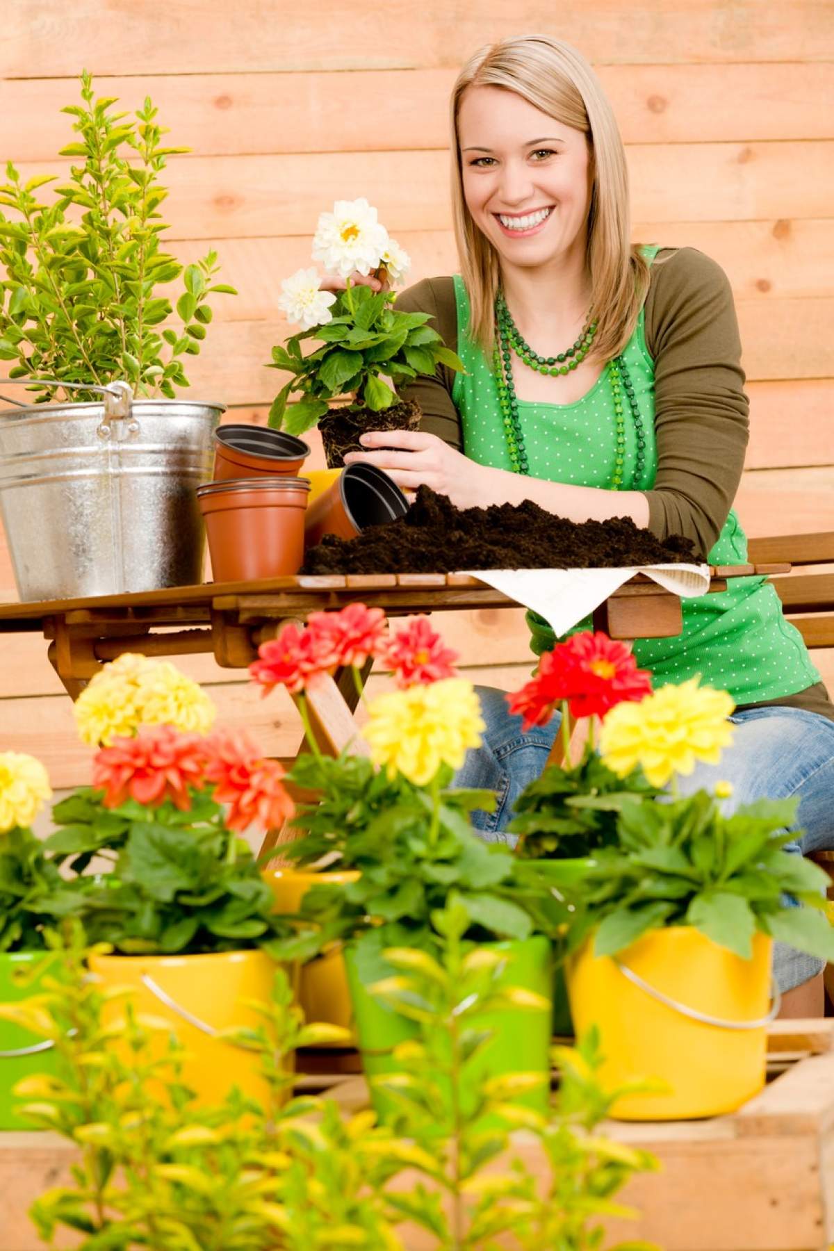 Fotografie cu o femeie care are grijă de plantele din ghivece