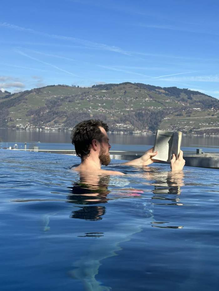Sorin Gadola în piscină cu o carte în mână.