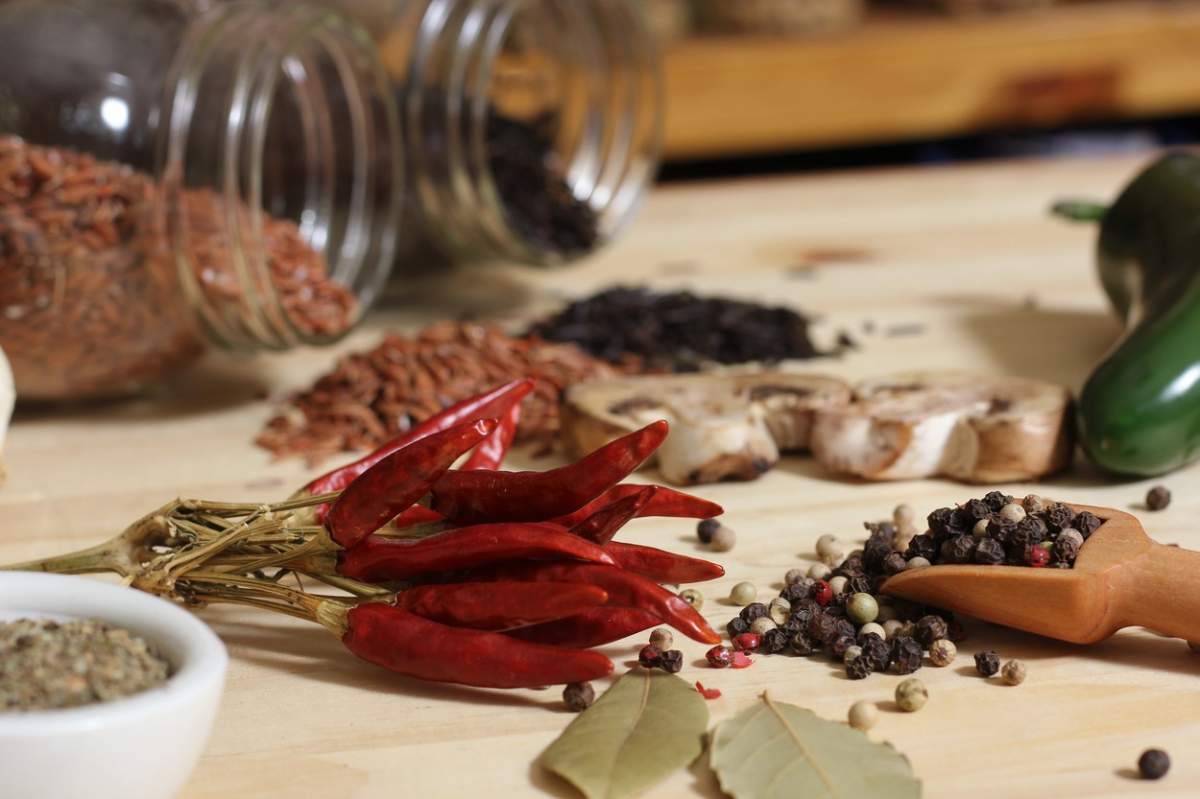 Ardei uscați , condimente și borcane de orez în fundal în bucătărie rustică