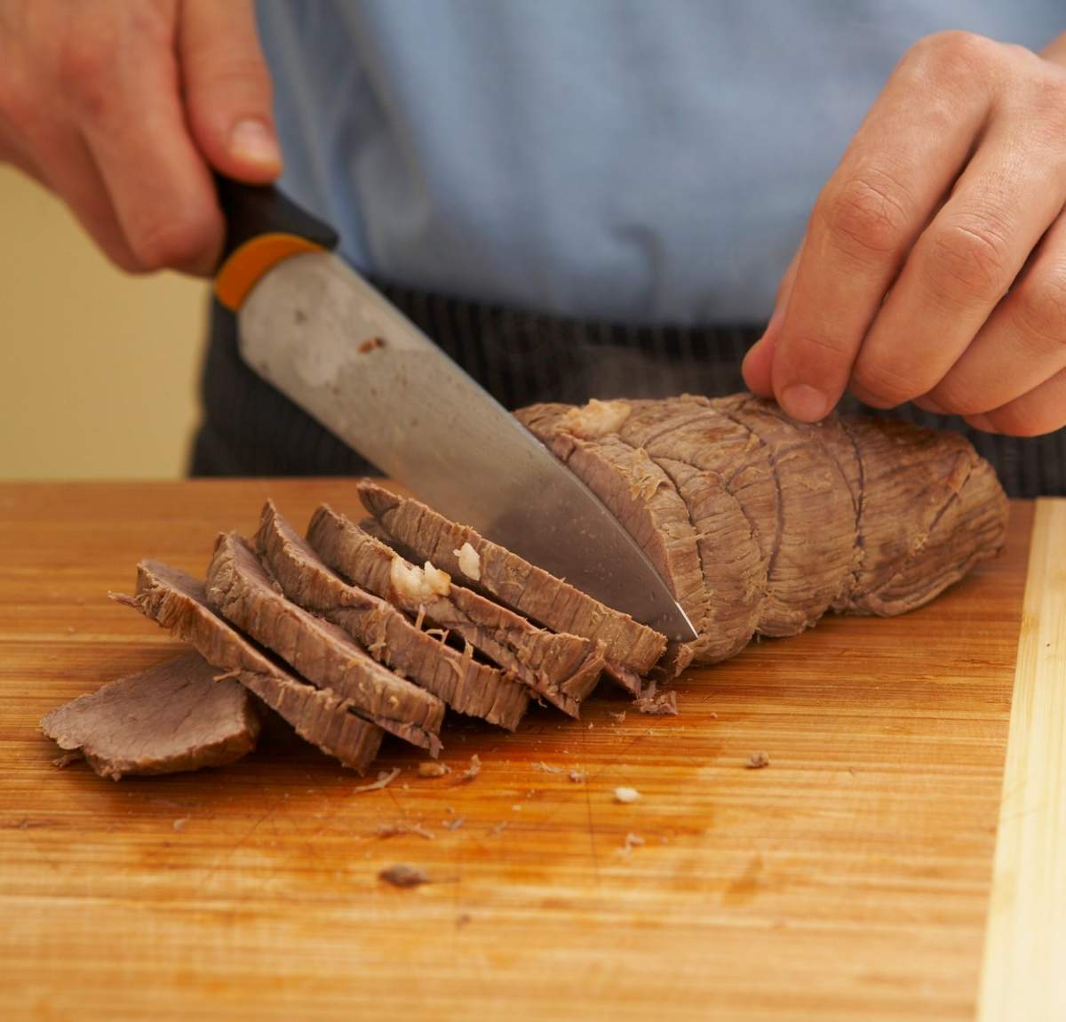 Fotografie cu un bărbat care taie carne de vită