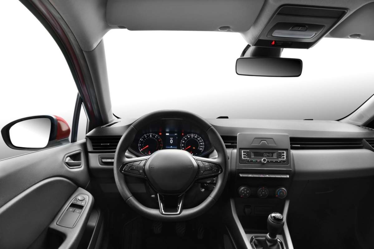 Fotografie din perspectiva unui șofer într-o mașină de pasageri modernă, surprinzând vederea volanului, a parbrizului față, a tabloului de bord, a schimbătorului de viteze