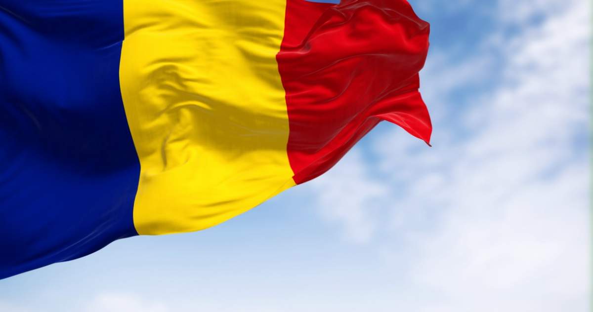 Steagul național al României fluturând în vânt într-o zi senină