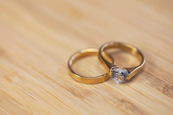 Verighete elegante de aur cu diamant pe fundal de masă din lemn. Mireasă și mire. Logodnă. Căsătoria de lux și conceptul de accesorii de nuntă.