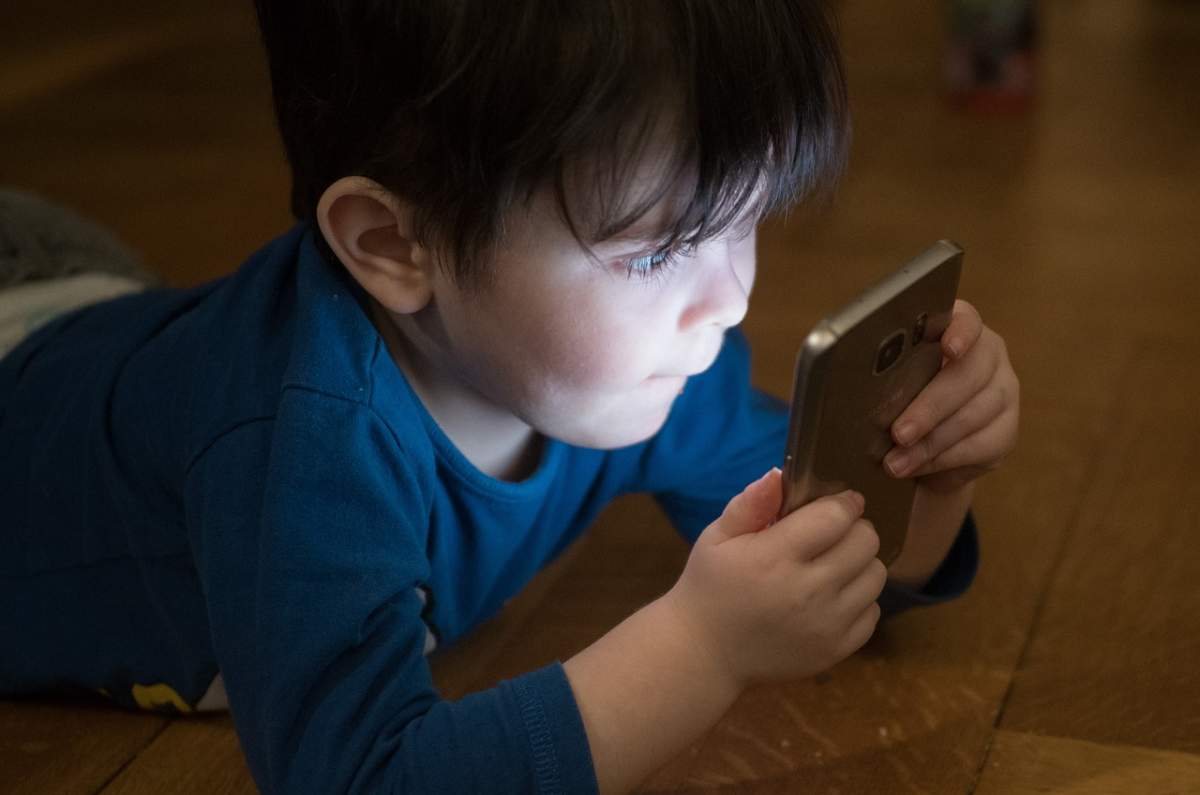 copil cu telefon în mână