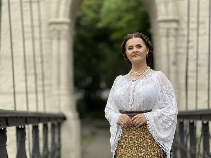 Niculina Stoican se uită în sus în costum popular