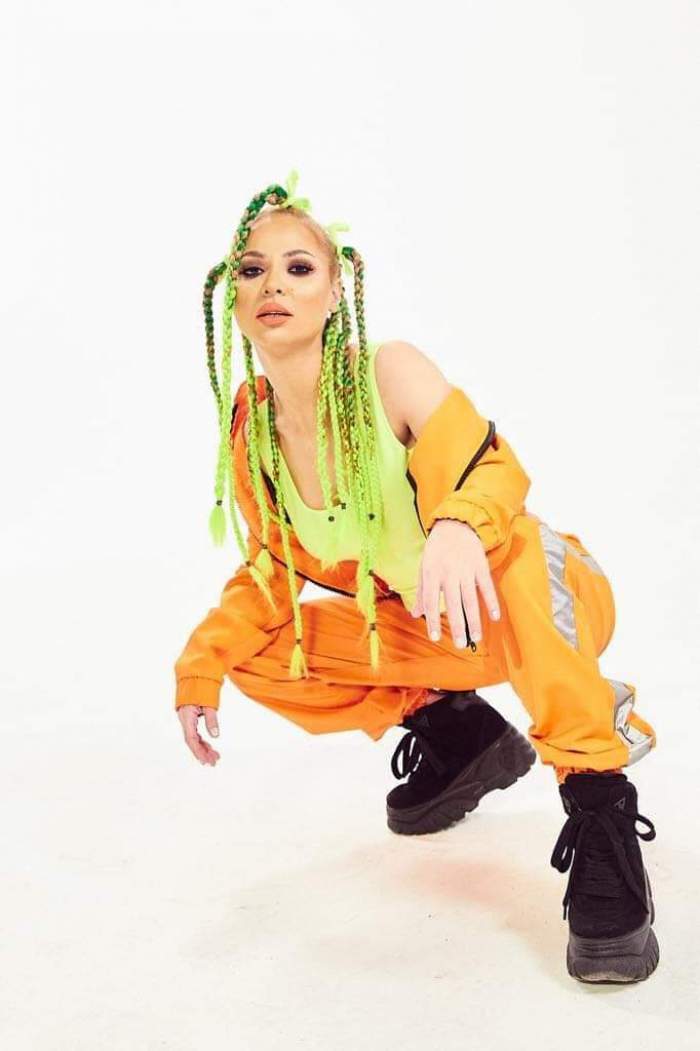 Alessia îmbrăcată în portocaliu, cu părul verde