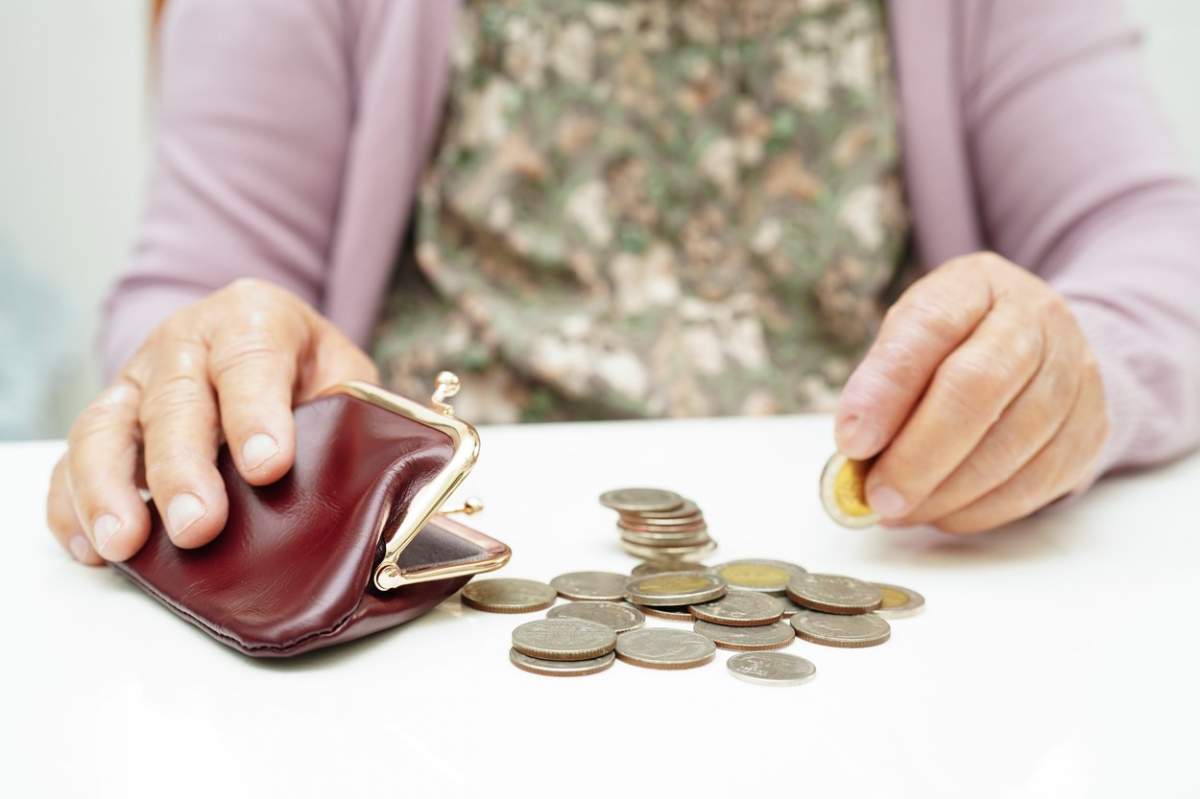 Bătrână pensionară care numără monede