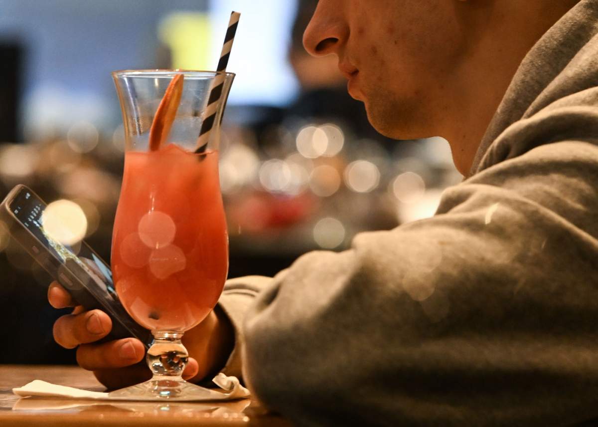 CRACOVIA, POLONIA - 21 DECEMBRIE: Un bărbat bea un cocktail într-un restaurant din orașul istoric vechi,