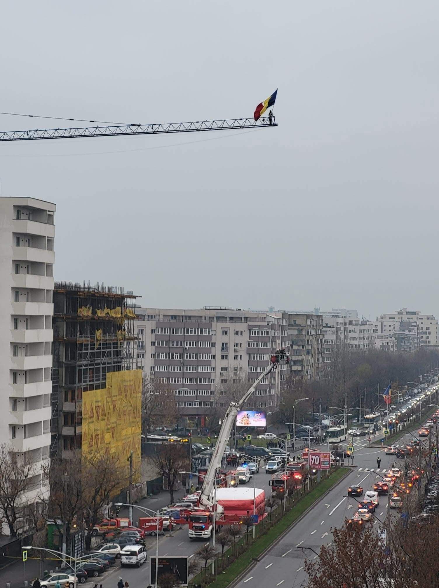 Scene controversate în Capitală. Un bărbat s-a urcat pe macara, cu drapelul României în mână / FOTO