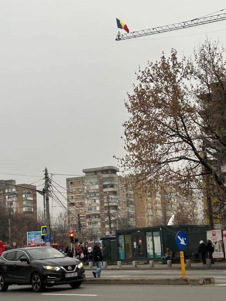 Scene controversate în Capitală. Un bărbat s-a urcat pe macara, cu drapelul României în mână / FOTO