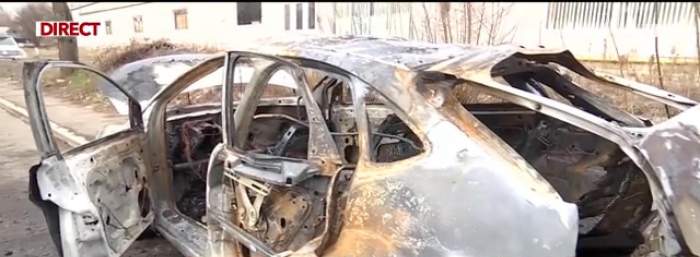 Imagine cu mașina care  explodat pe o stradă, în București, după ce a fost stins incendiul