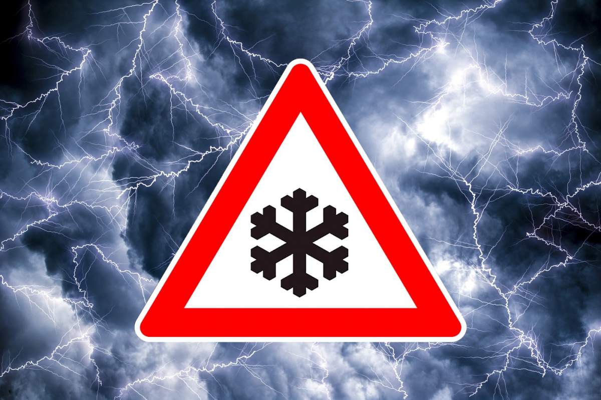 O pictogramă triunghiulară în formă de triunghi de avertizare cu o avertizare de pericol împotriva unui cer dramatic cu fulgere intermitentă avertizează despre ninsori și furtuni de zăpadă