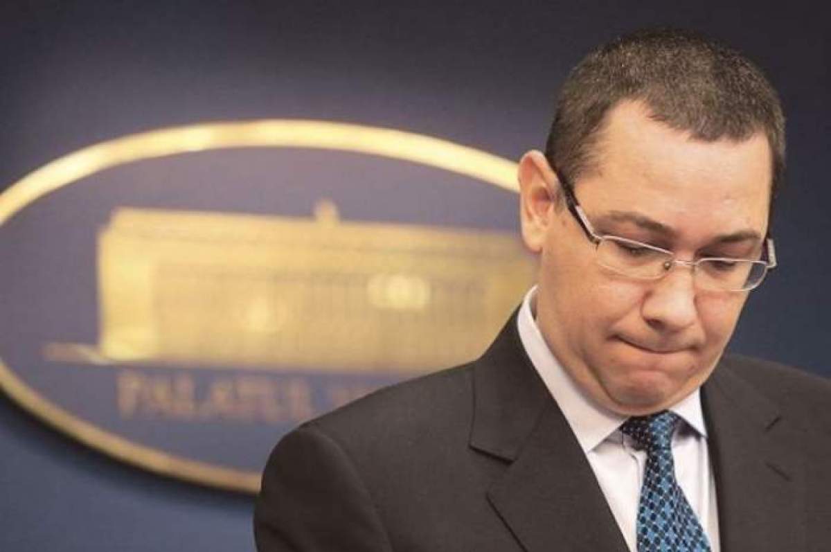 Victor Ponta se uită în jos îmbrăcat în costum