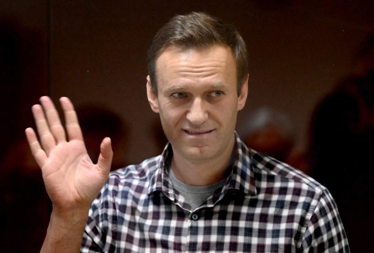 Liderul opoziției ruse Alexei Navalny stă în interiorul unei celule de sticlă în timpul unei ședințe de judecată la tribunalul districtual Babușkinski din Moscova, pe 20 februarie 2021.