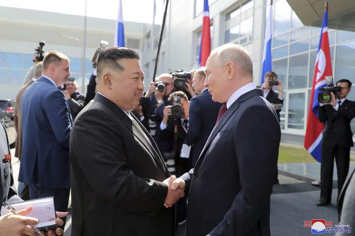 Vladimir Putin și Kim Jong Un la o întâlnire, îmbrăcați în costume