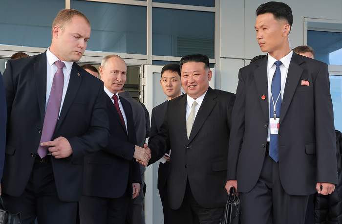 Vladimir Putin și Kim Jong Un la o întâlnire, îmbrăcați în costume