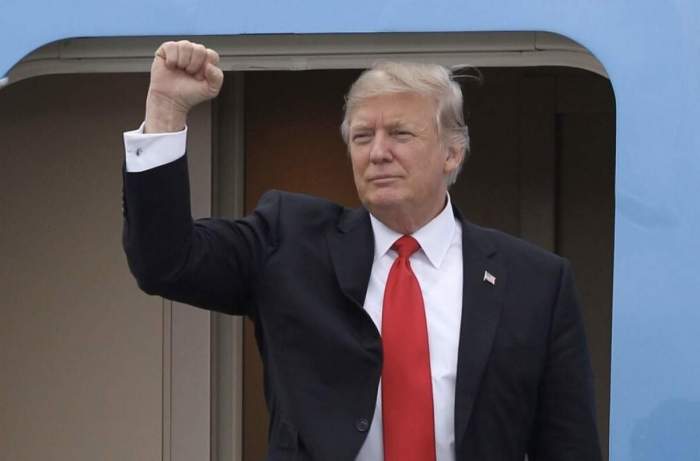 Donald Trump  cu o mână ridicată în sus