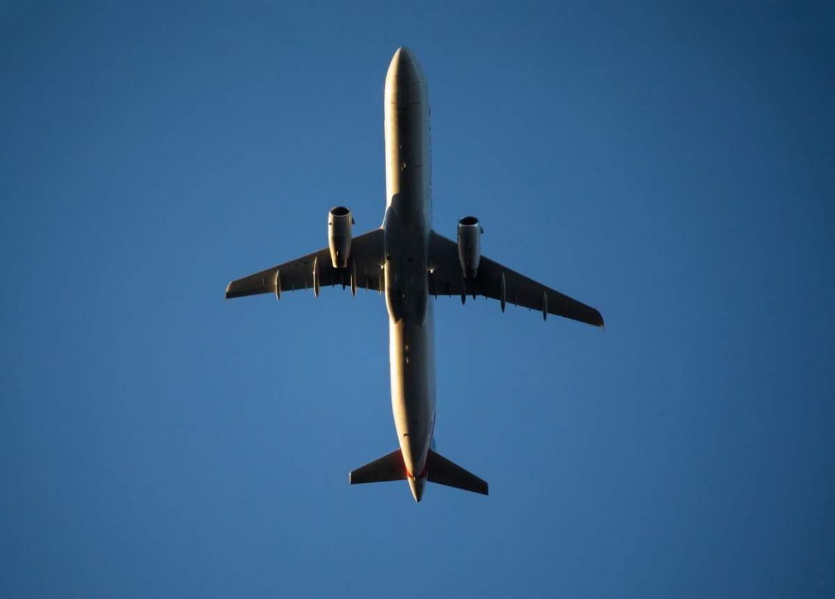 Un avion comercial zboară jos deasupra capului la scurt timp după decolare.