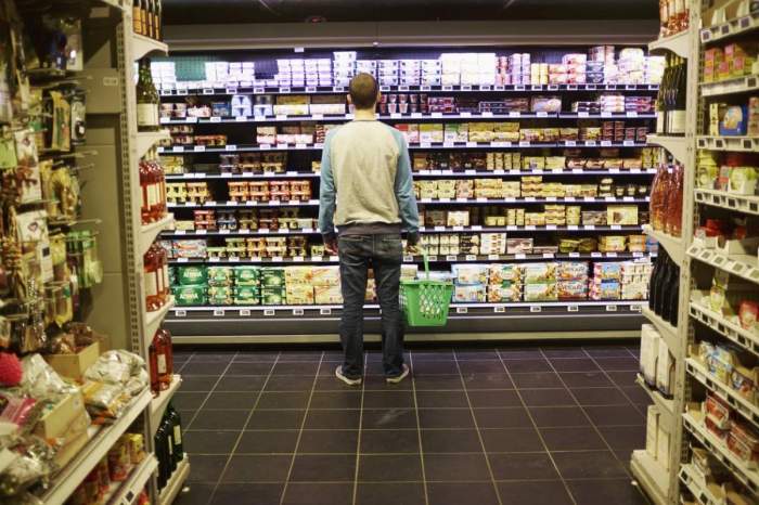 Un bărbat în supermarket, printre rafturi