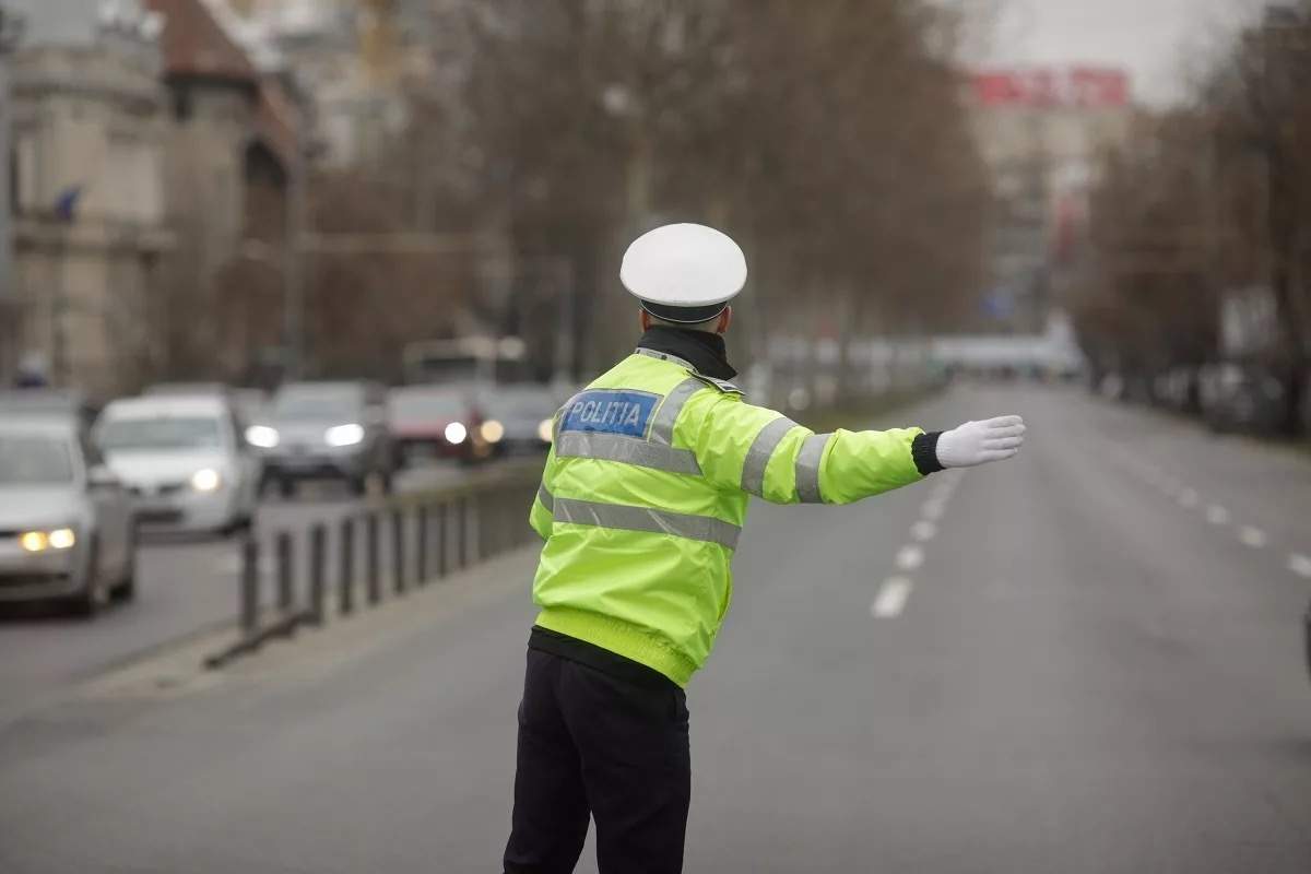 Imagine cu polițist care dirijează traficul
