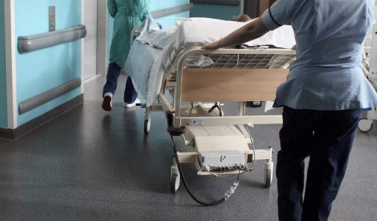 Imagine cu medici care transporta un pat de spital
